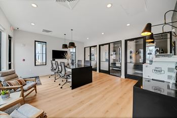 A living room with a kitchen and a table and chairs